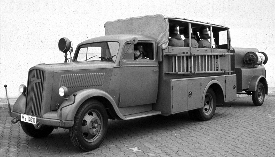 Als „Katze“ wurde der leichte Opel Blitz KzS 8 auch gerne bezeichnet. Das Reichsluftfahrtministerium (RLM) hat diesen Fahrzeugtyp in großen Stückzahlen für den Luftschutz bauen lassen. Ab dem 1. Juni 1942 ging der Sicherheits- und Hilfsdienst in den Befehlsbereich der Polizei über und wurde als Luftschutzpolizei (LSPol) bezeichnet. Daher fanden sich nach Kriegsende auch in den Reihen der FF München einige dieser Fahrzeuge wieder.