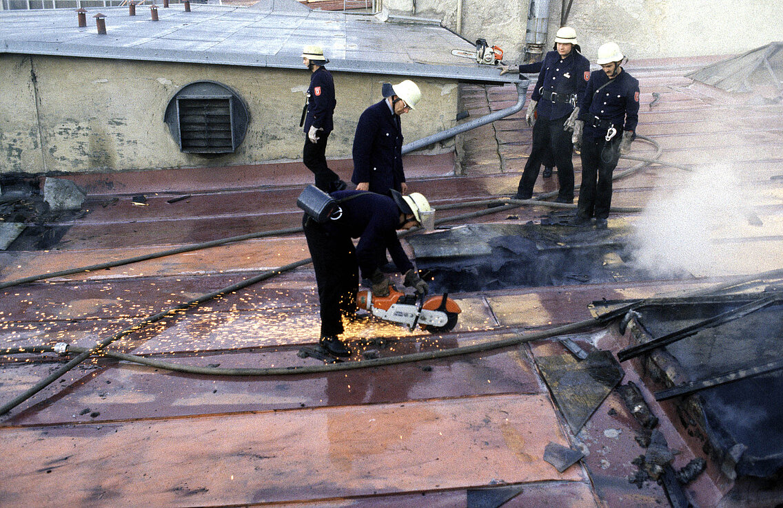 Kräfte der Freiwilligen Feuerwehr beim Öffnen der Dachhaut um versteckte Glutneser aufzuspüren
