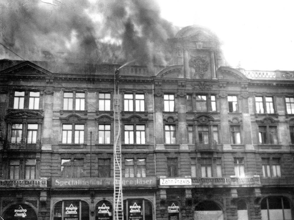 Ein Feuerwehrmann versucht im Außenangriff auf der Schiebleiter die Flammen aus dem Dachgeschoß des Mathäser zu bekämpfen